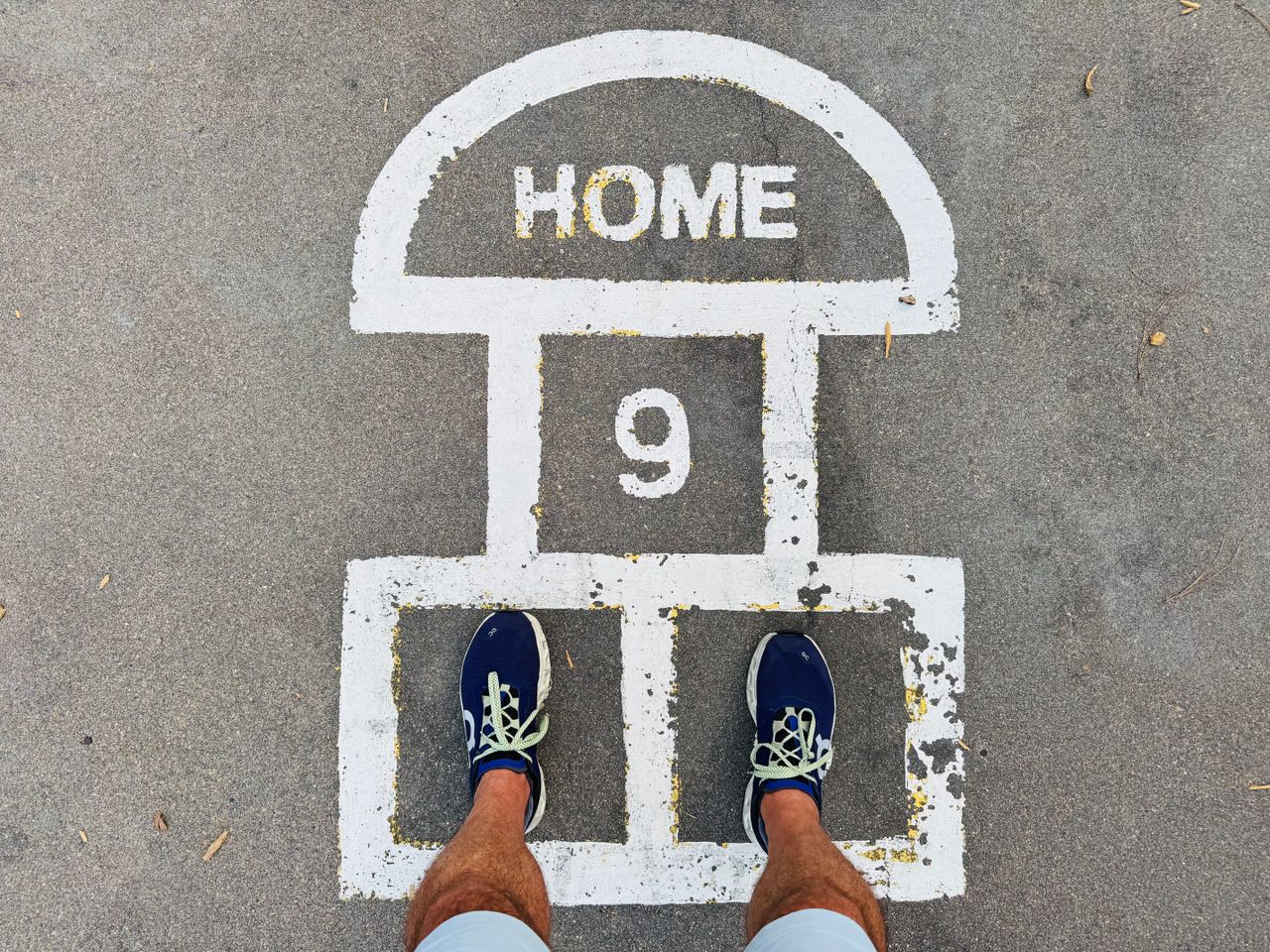Overhead shot of feet on a hopscotch court with HOME 9 marking.