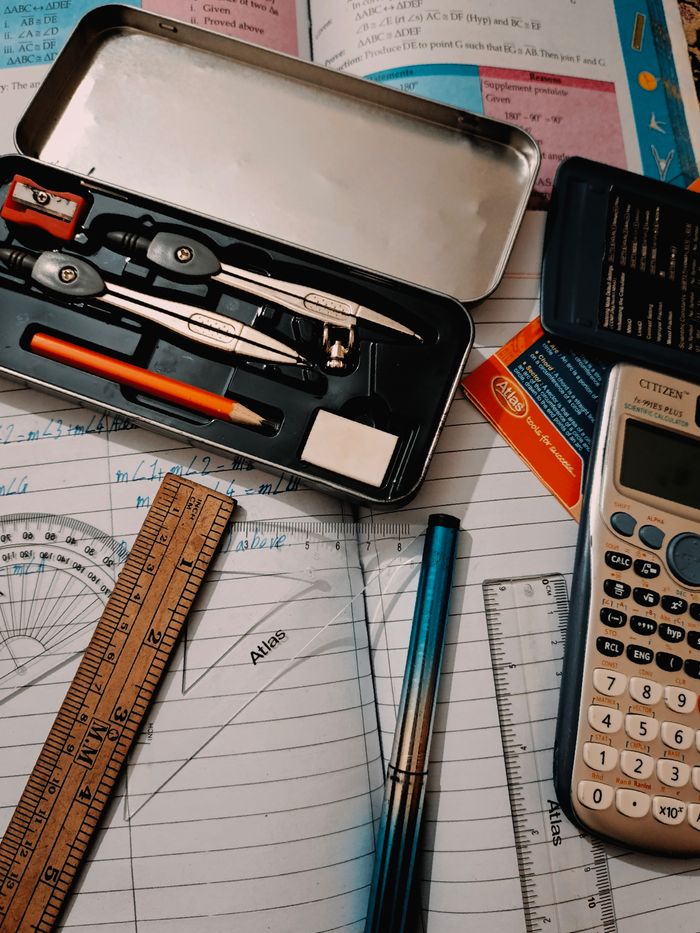 A collection of stationary tools for studying math, including a calculator, compass, and ruler.